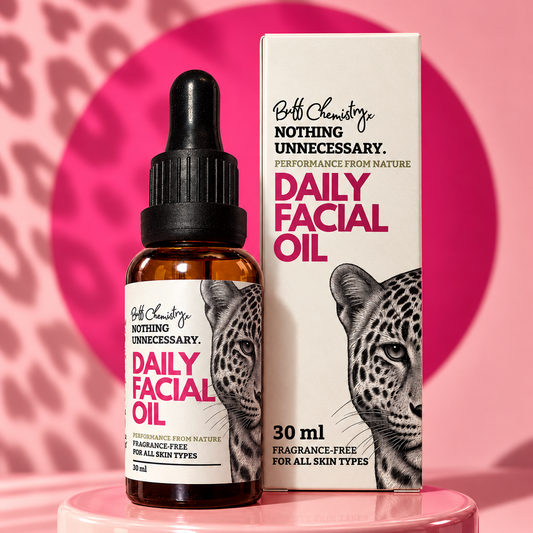 A bottle and box of Buff Chemistry Daily Facial Oil, featuring a leopard graphic on the label and box, set against a pink  background .